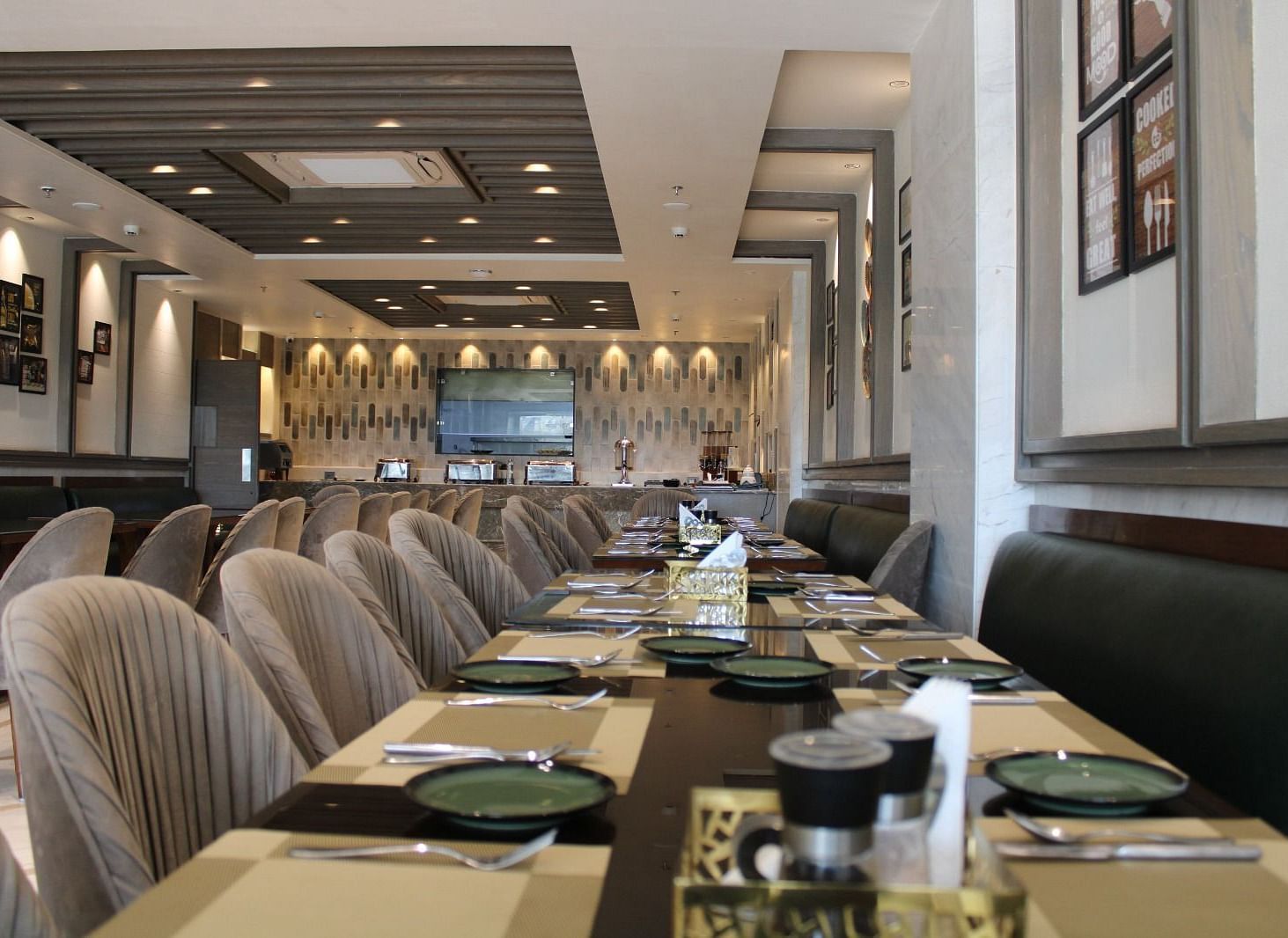 A well-arranged dining space featuring tables with chairs and neatly set cutlery at  BluSalzz Residence, Amritsar